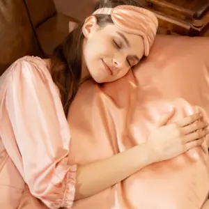 Mujer durmiendo con Antifaz de Dormir y sobre Funda de Almohada de 100% Seda Morera AMBERSPACE 22 Momme